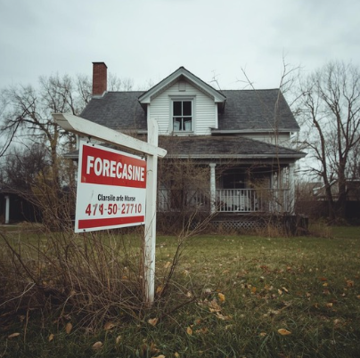 House with a foreclosure sign in front of it