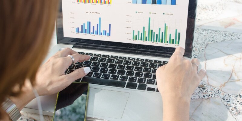 A person looking at a computer with a graph on the screen