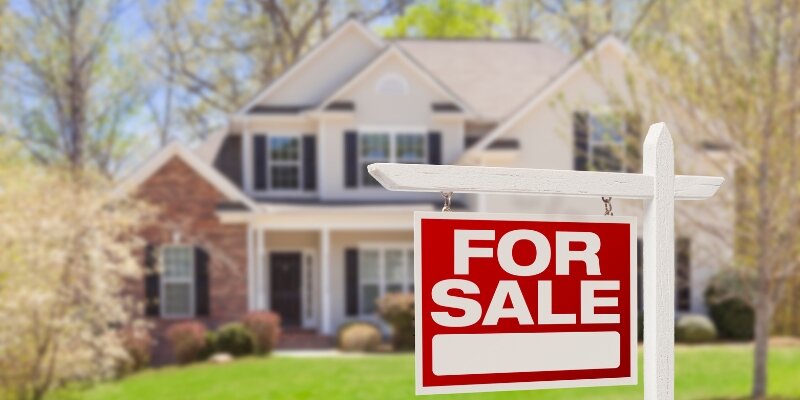 A picture of a house with a 'For Sale' sign, representing the question 'How soon after buying a house can you sell it', which is a common concern for buyers regarding recurring closing and moving