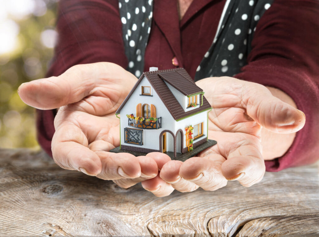 Learn the proper way of selling an inherited Illinois property Chicago, Illinois owner holding a model home of the house they inherited
