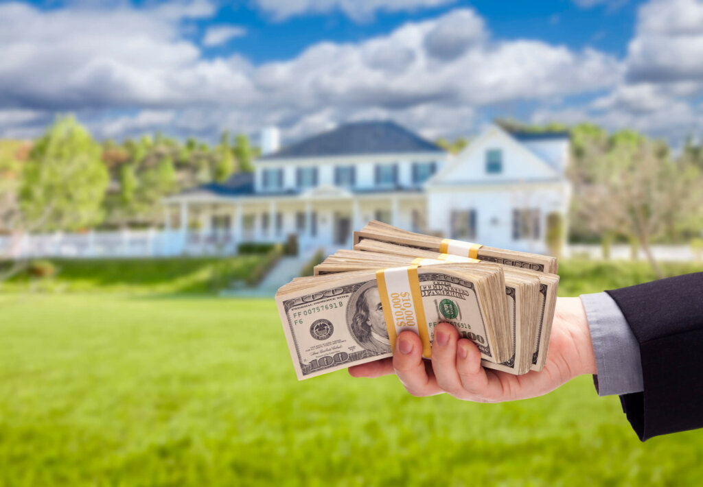 Learn how to sell your Illinois home fast for cash Illinois person holds cash in front of house to buy