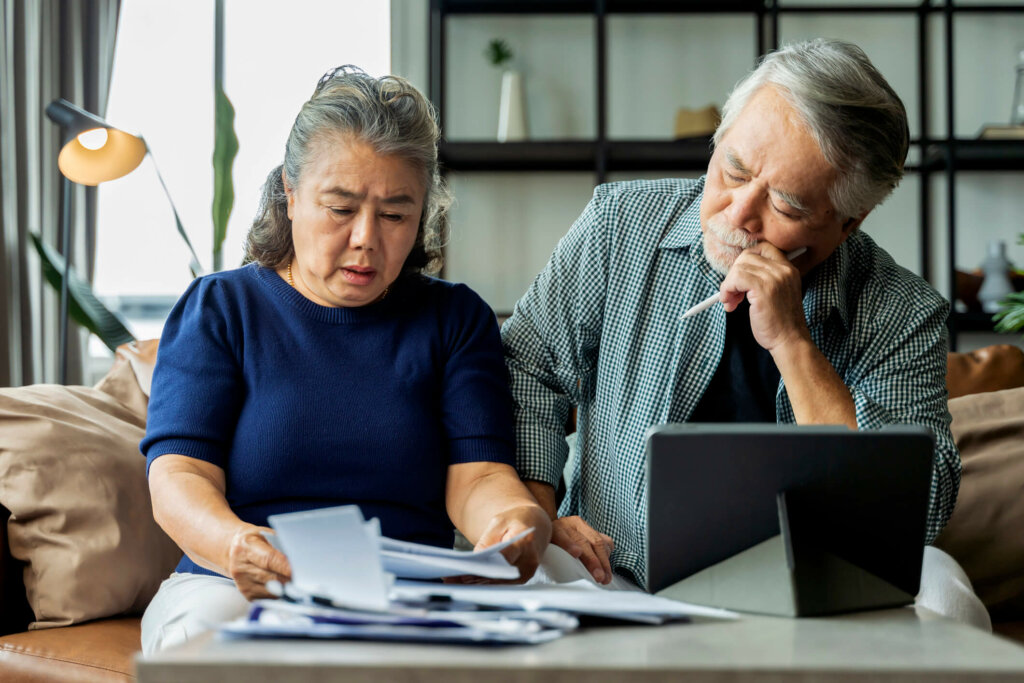 Learn why you want to sell your Illinois home for cash. Older Illinois Asian couple calculate costs and bills while deciding if they want to sell their house.