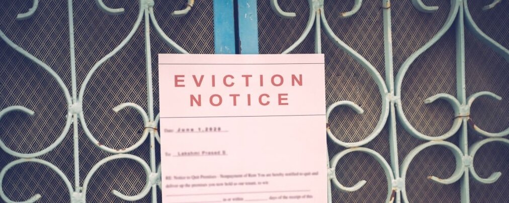 Foreclosed or eviction notice on a main door with blurred details of a house