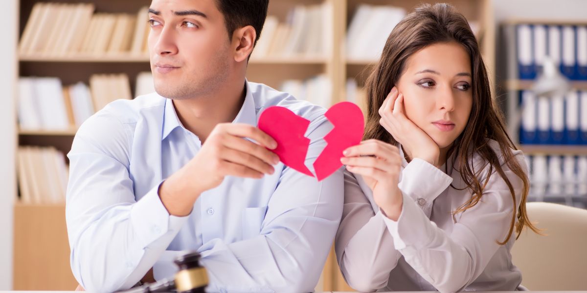 couple holding each half a of a paper heart symbolling divorce