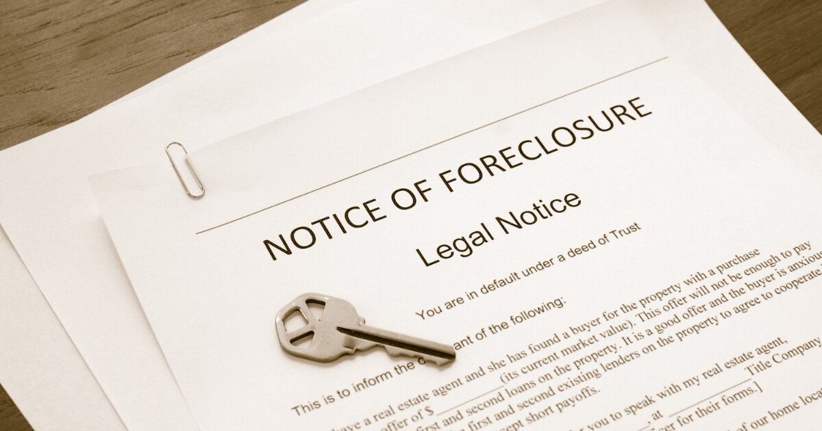 Legal foreclosure notice with a key placed on top, highlighting the challenges of foreclosure for homeowners.