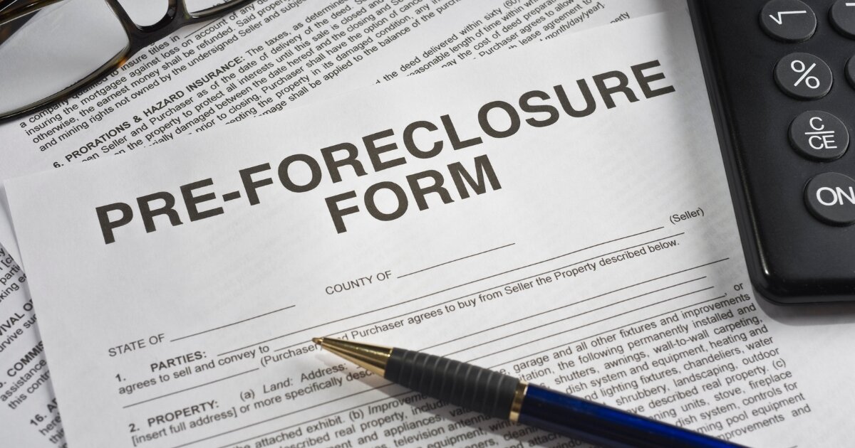 Pre-foreclosure form with a pen and calculator, symbolizing the financial planning needed to address mortgage difficulties.