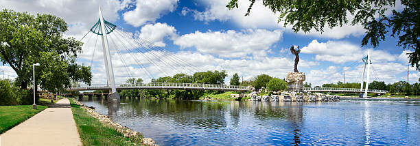 This is a photo of the Keeper Of The Plains statue and foot bridge across the Arkansas River near downtown in Wichita, Kansas.
