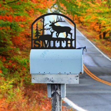 Custom metal cutout with deer and a last name sitting on top of a mailbox