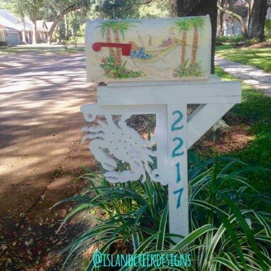 decorative grass around mailbox painted with palm trees and a decorative crab