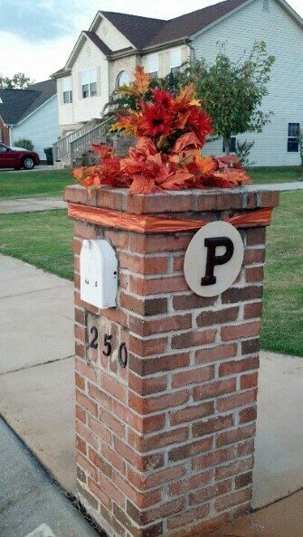Brick mailbox with orange flowers and leaves on top
