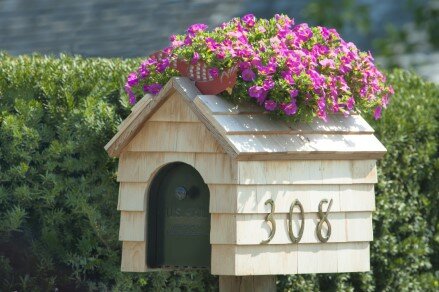 House shaped mailbox with pink flowers on top