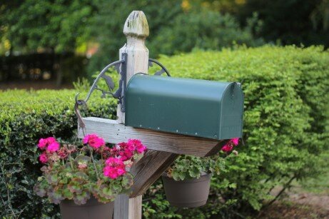 Green mailbox with hanging planters on each side