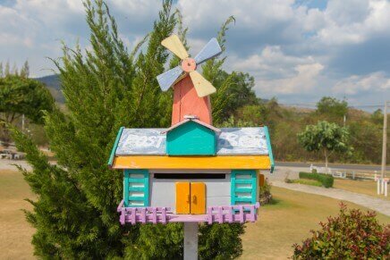 colorful wood house shaped mailbox with windmill