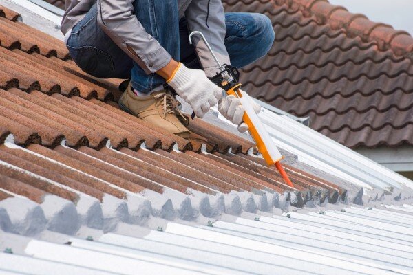 applying caulk to roof