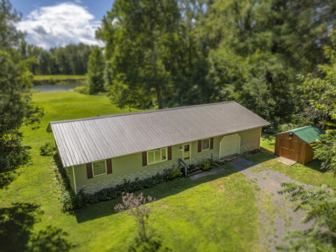 Front view of affordable waterfront home for sale near Sylvan Beach NY with private gravel driveway