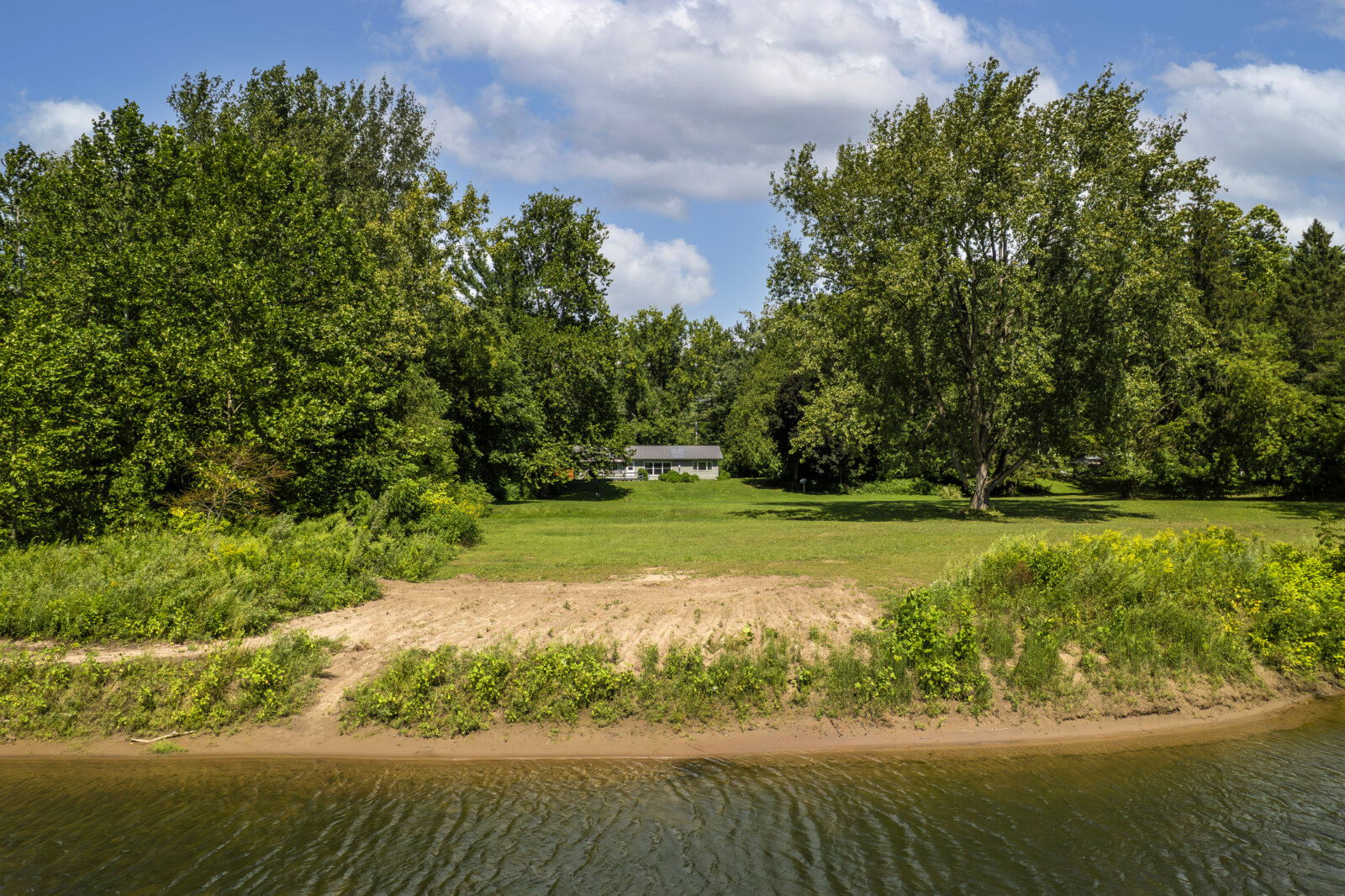 Scenic backyard with river access at affordable waterfront home for sale in Blossvale NY
