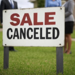 Frustrated home seller standing in front of a house with a "Sale Canceled" sign — representing recent increase in canceled home sales.