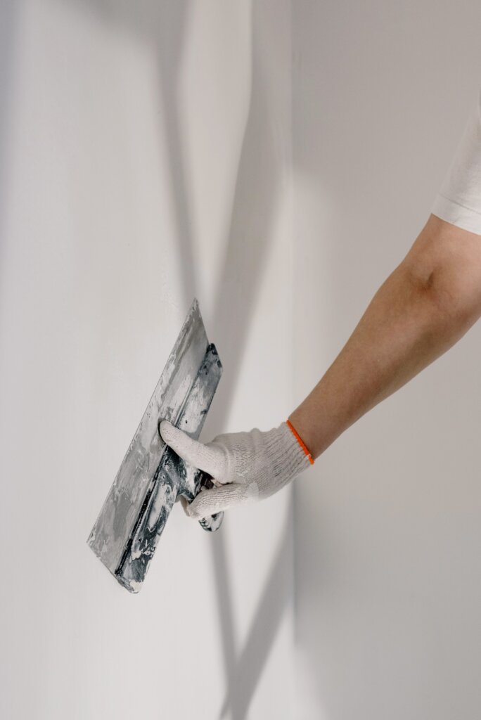A person repairing drywall.