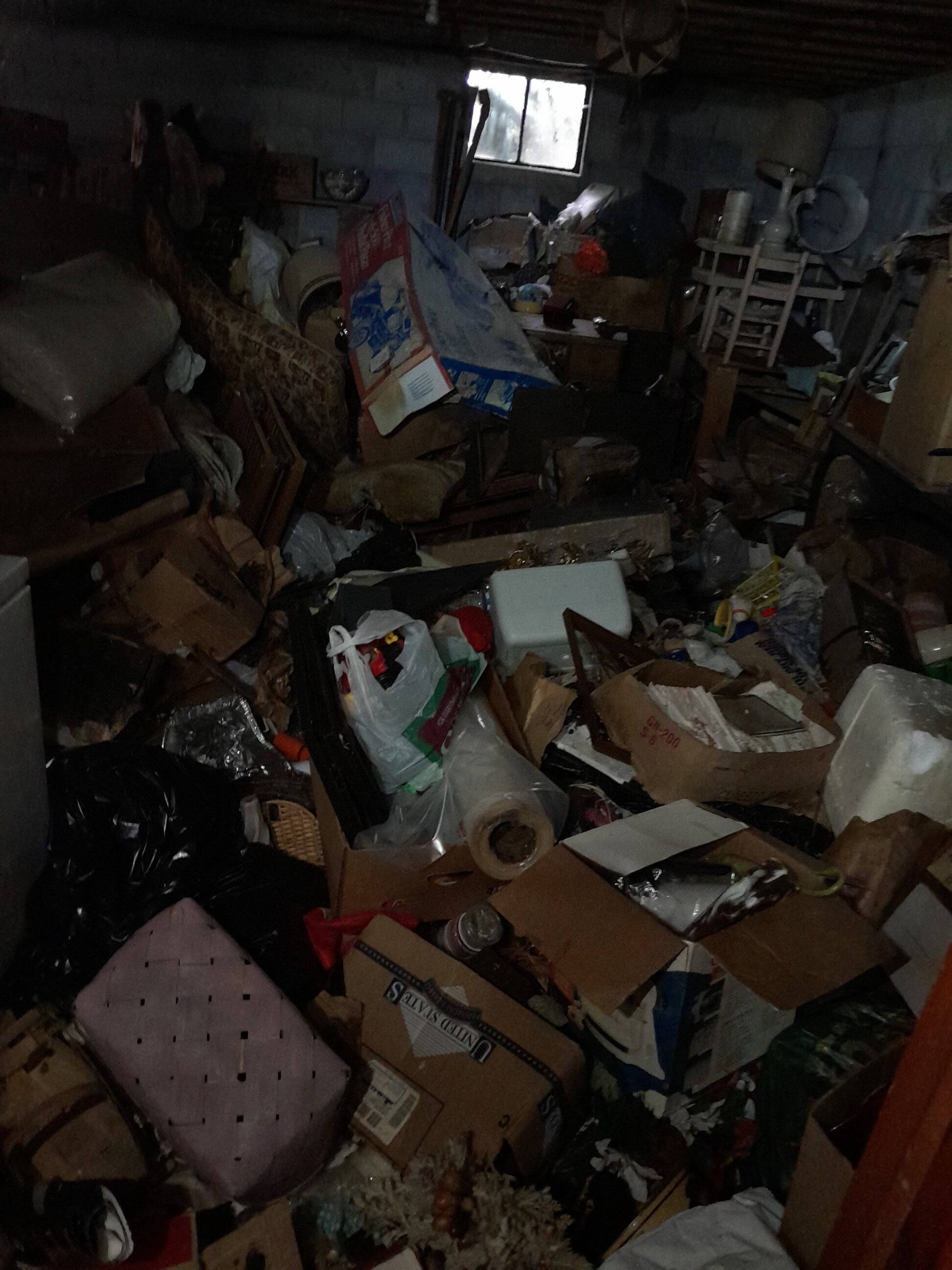 A room packed with items in a hoarded home Tri-Cities Homebuyers bought and repaired.