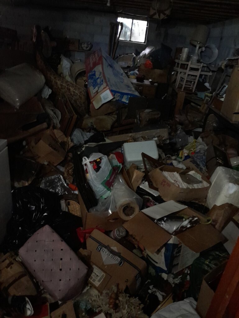 A completely hoarded room with an overwhelming amount of things piled to the ceiling.