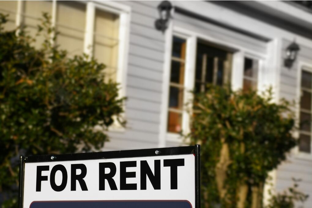 House with a for rent sign in the front yard.
