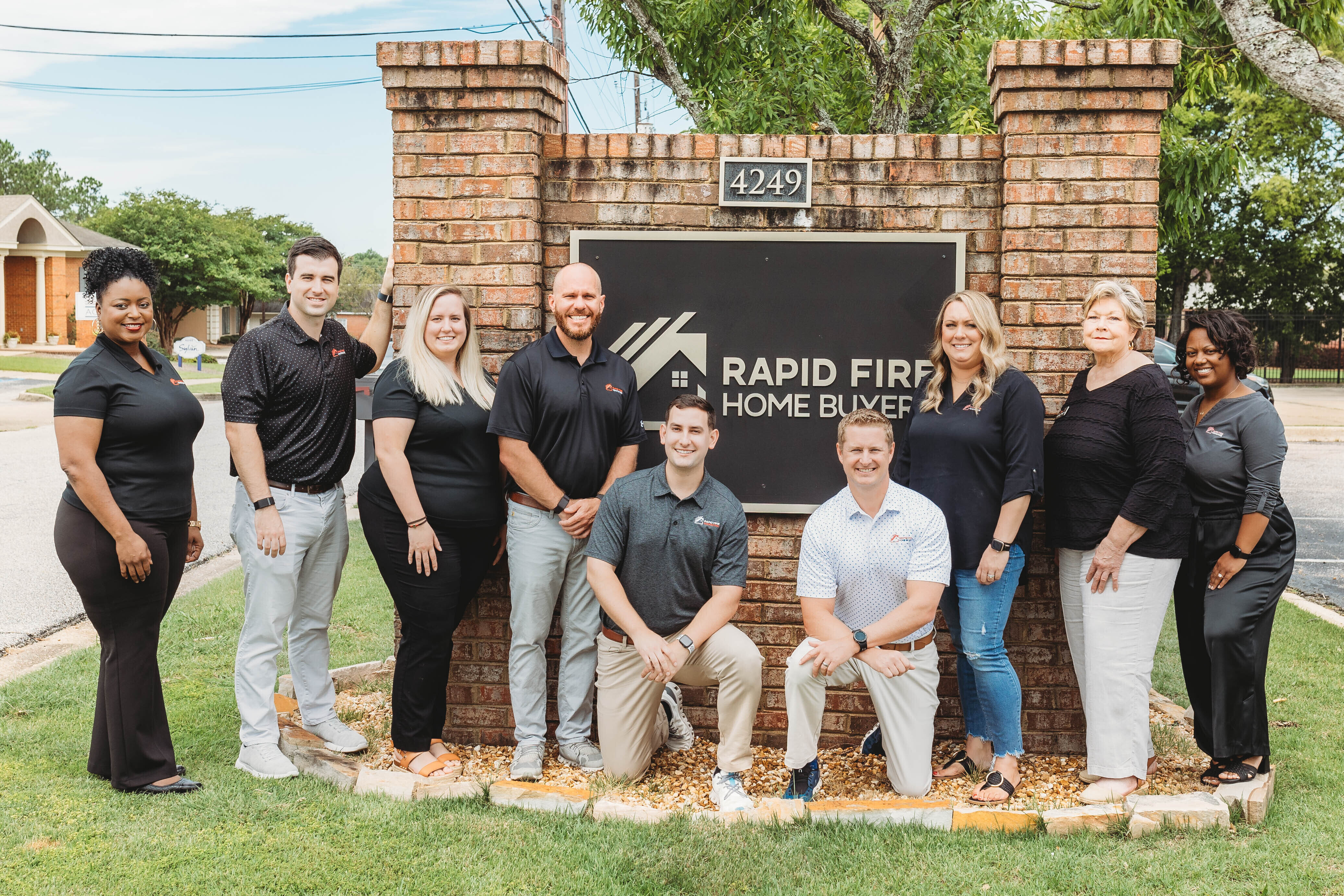 Rapid Fire Home Buyers team in front of our office sign.