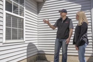 Rapid Fire Home Buyers meeting with a homeowner reviewing their home in order to buy their house quickly.