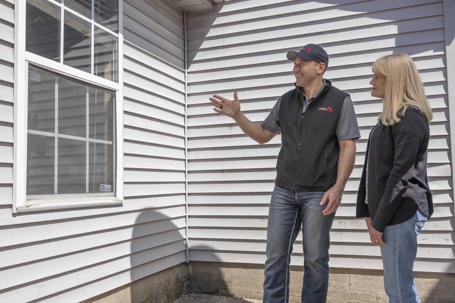 Rapid Fire Home Buyers meeting with a homeowner reviewing their home in order to buy their house quickly.