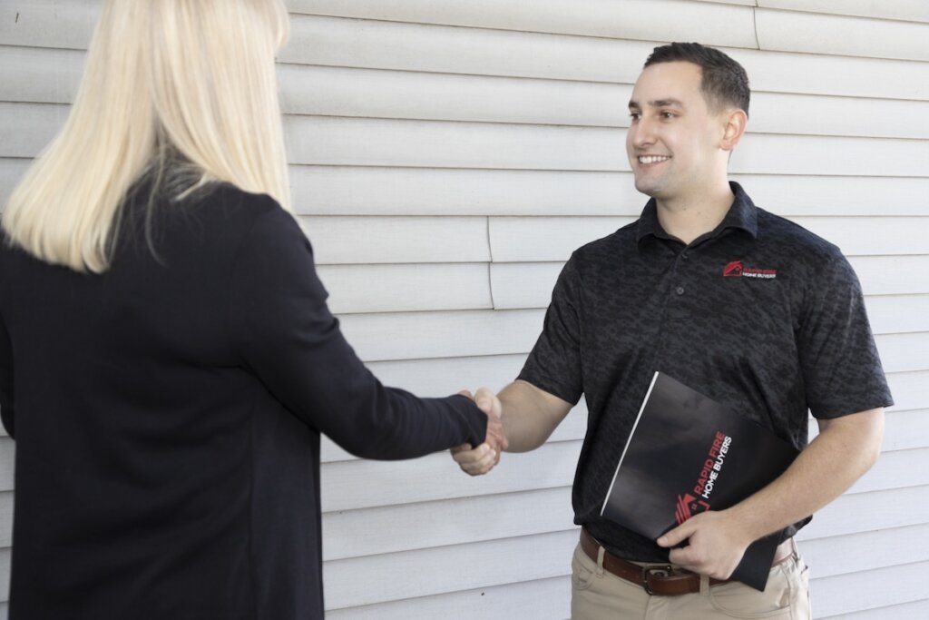 Helpful and courteous rapid fire home buyers home buying specialist greeting a homeowner at their door ahead of their appointment.