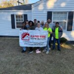 Rapid fire home buyer team and volunteers pose for a picture in front of a home they generously donated to a deserving family in Montgomery AL.