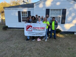Rapid fire home buyer team and volunteers pose for a picture in front of a home they generously donated to a deserving family in Montgomery AL.