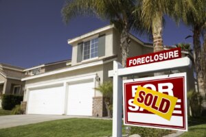 Foreclosure house with a sold sign in the yard after a homeowner sold their house quickly with Rapid Fire Home Buyers.