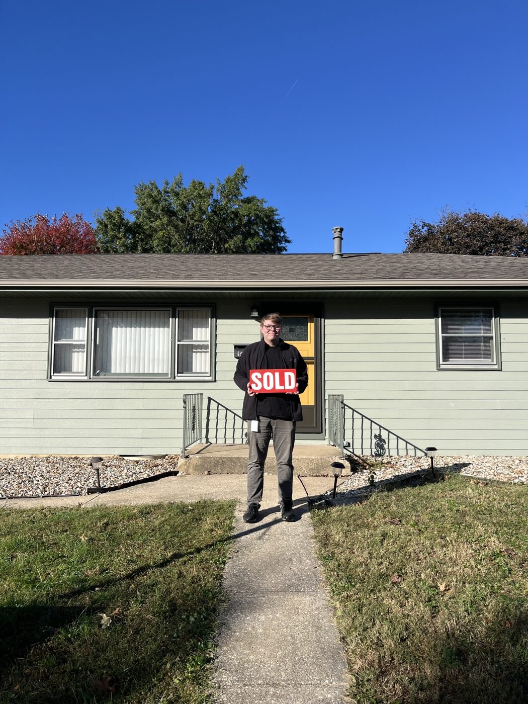 A client celebrating outside a green home.