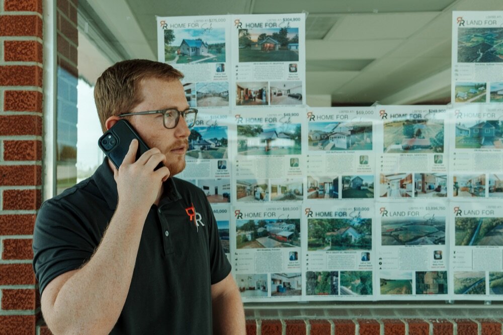 Cole Rorebeck speaking on the phone outside the real estate office