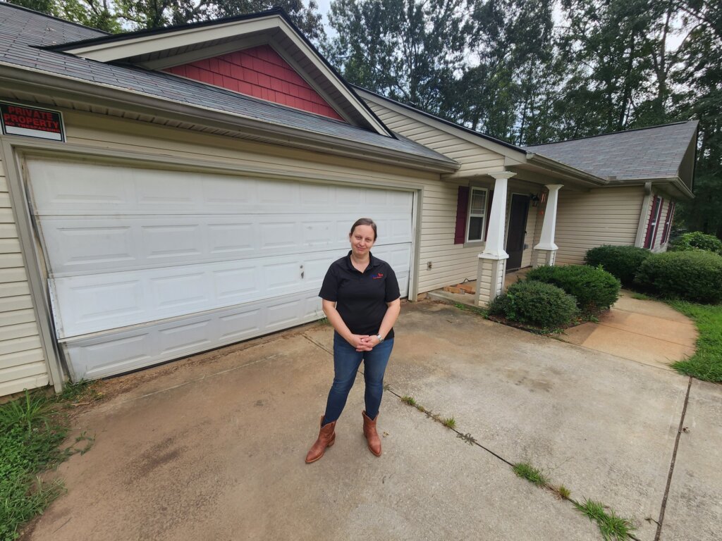 Natalie standing in front of a house purchased in Jefferson, GA