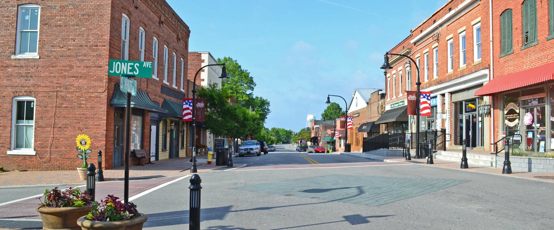 A vibrant cityscape of Wake Forest Downtown, featuring charming shops, cozy cafes, and historic buildings. Time is money when it comes to real estate transactions – take advantage of our expertise and sell your house fast Wake Forest NC today.