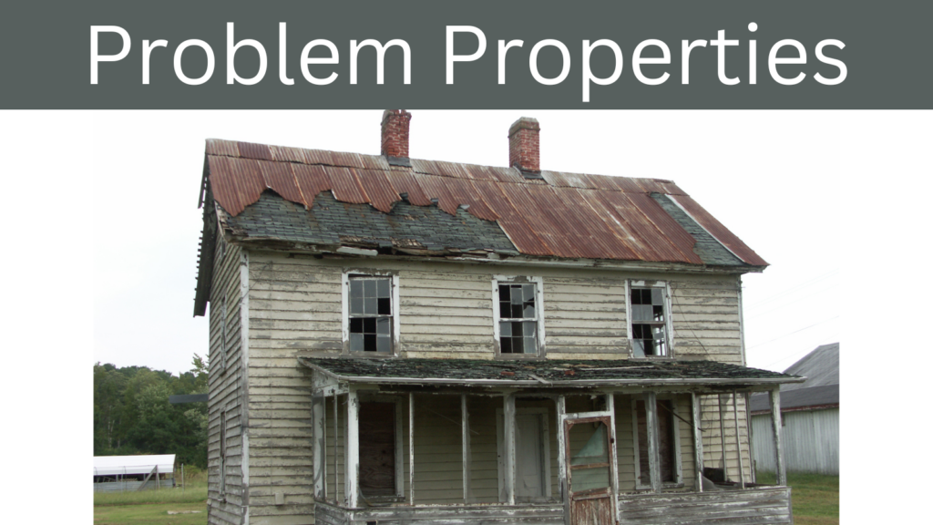 Old, run-down house with peeling paint and broken windows, representing problem properties.