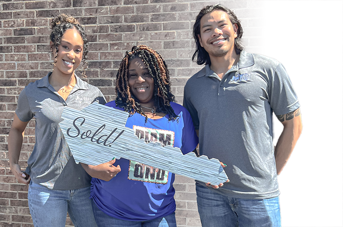 Mark and Nicole from Best Texas House Buyers posing with a happy home seller holding a "Sold" key, celebrating a successful cash sale and stress-free experience in Dallas