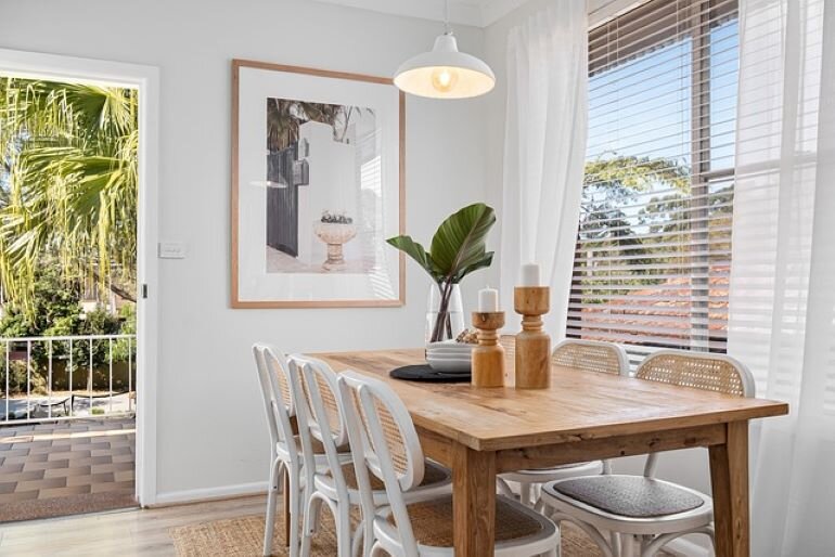 Wooden dining room table with white chairs