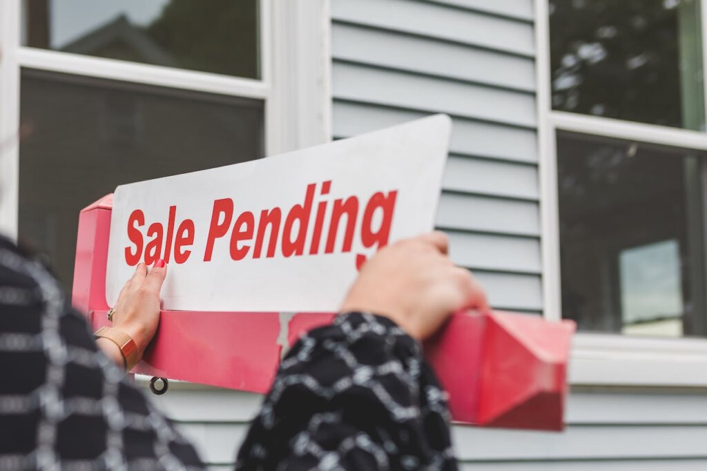 A sale pending sign being put in place