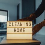 A person touching a lightbox that says “cleaning home”.
