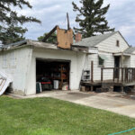 A front facade of a weathered, older house clearly in need of repairs, featuring peeling paint and an overgrown yard.