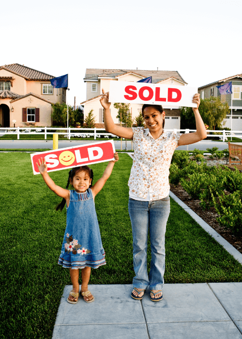 mother and daughter standing with sold signs, sold to cash home buyer
