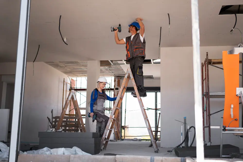 A couple of guys in construction fixing a house.