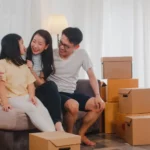 family of three sitting down with brown boxes