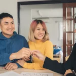 Asian couple shaking hands with an agent