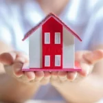 Man holding a red house