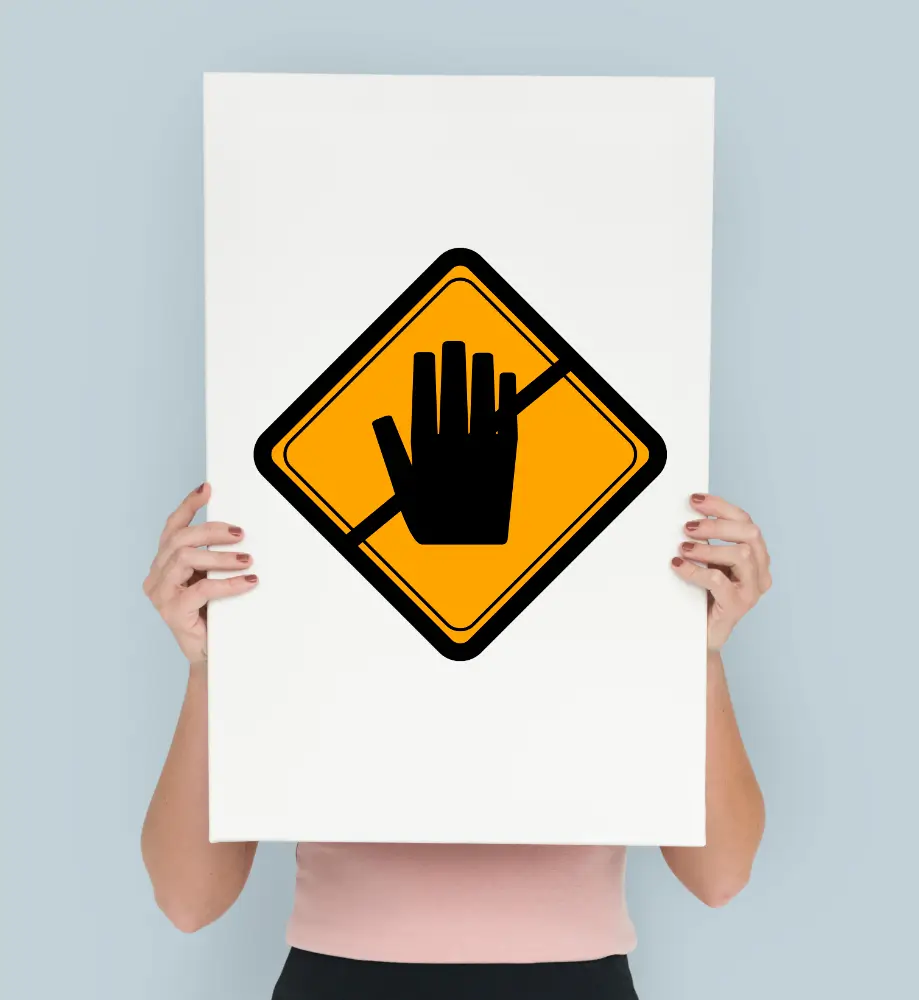 a woman holding up a sign with a hand on it
