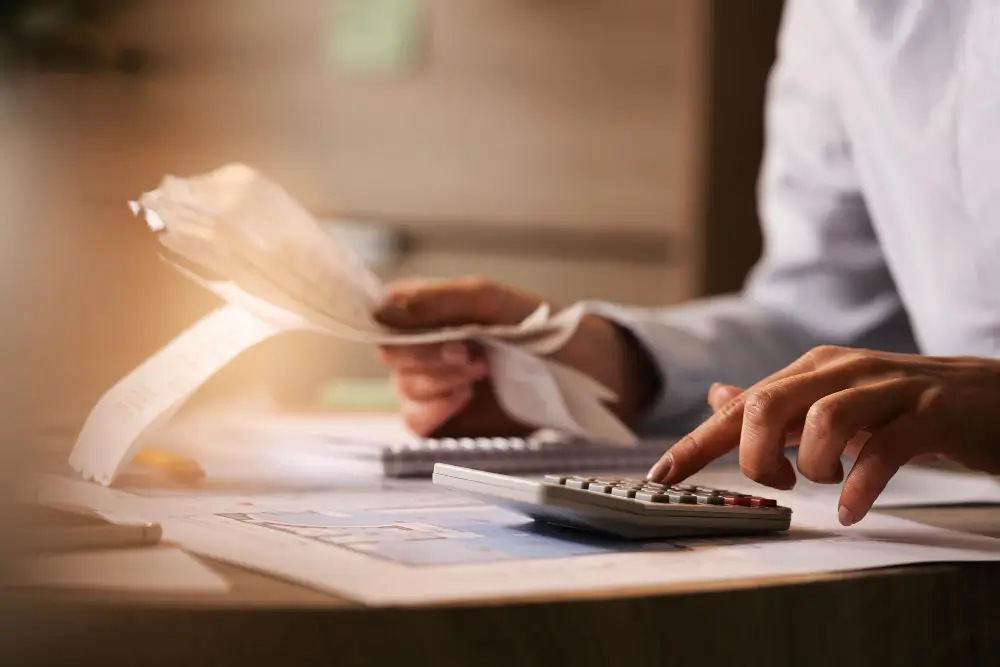 a person using a calculator on a desk