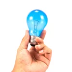 a person holding a light bulb in their hand